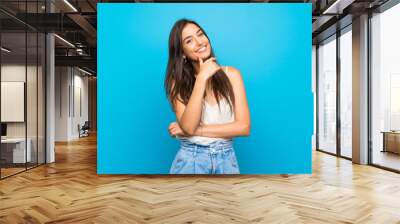 Young woman over isolated blue background smiling Wall mural