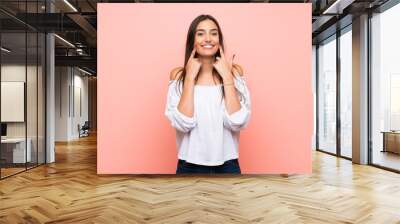 Young woman over isolated pink background smiling with a happy and pleasant expression Wall mural