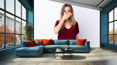 Young woman over isolated white background covering mouth with hands Wall mural