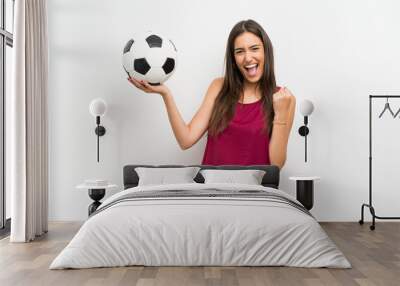 young woman over isolated white background holding a soccer ball Wall mural