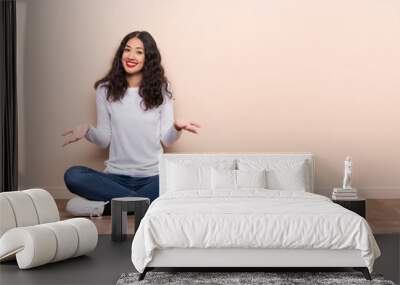 Young woman sitting on the floor smiling Wall mural