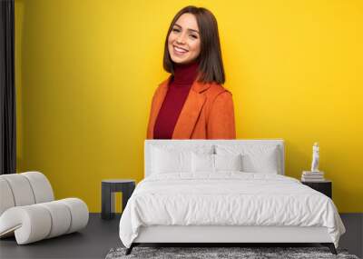 Young woman with coat smiling Wall mural