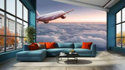 Commercial airplane jetliner flying above dramatic clouds in beautiful light. Travel concept. Wall mural