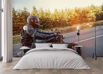 Man seat on the motorcycle on the forest road. Wall mural