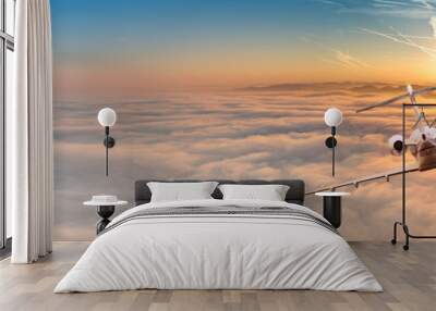 Private jet plane flying above dramatic clouds. Wall mural