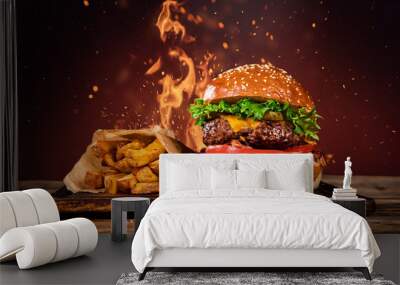 Tasty burger with french fries and fire. Wall mural