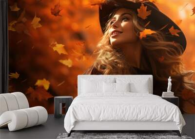 Beautiful young woman in an orange autumn park with falling leaves Wall mural