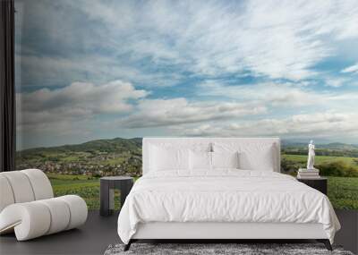 Moving clouds in two directions, above the village of the Krhova Beskydy Czech republic looking at horizon around with visible hills and mountains during sunny days and field for crop Wall mural