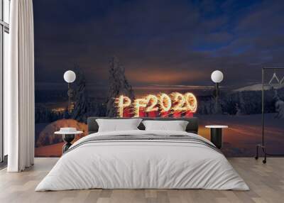 PF 2020 new year symbol drawn with sparklers by a woman in snowy landscape Wall mural