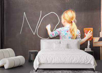 Cute little girl writing no on chalkboard Wall mural