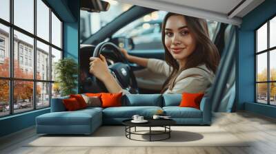 Cheerful woman behind the wheel, on a journey or contemplating travel, enjoying a morning commute in her vehicle Wall mural