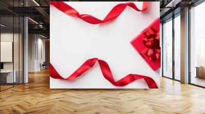 Festive red satin ribbon and box on white background symbolizing holiday spirit Wall mural