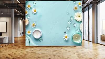 Spa products candle and flowers arranged neatly on light blue surface Text space available Wall mural