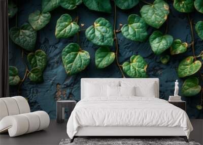 Vibrant green plant leaves are captured up close against a striking blue wall background, creating a visually appealing contrast Wall mural