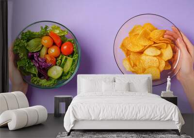 Two female hands is holding a salad bowl and chips with studio concept. Healthy food lifestyle vs processed food. Wall mural