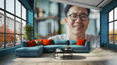 Portrait of a smiling asian man wearing glasses. Happy and confident, this young Asian professional beams for the camera, showcasing diversity and success in the workplace. Wall mural