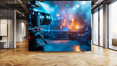 Professional camera recording live event. Professional video camera setup on a tripod capturing a concert or live music event, with blurred stage lights in the background. Wall mural