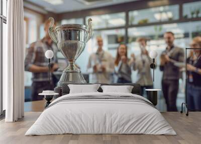 Silver trophy with celebrating team in background. Silver trophy award for business achievement with happy team celebrating in a modern office, recognizing success and hard work Wall mural