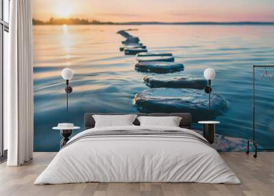 Stepping stones to the sunset. A tranquil sunset scene with stepping stones leading out across the water, inviting you on a journey of peace and tranquility. Wall mural