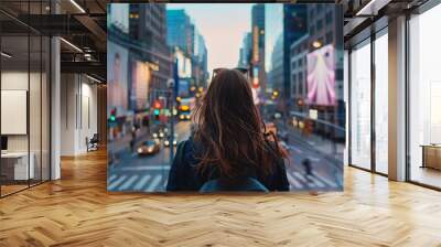 Woman exploring times square. Young woman with long hair looks out at the bright lights and bustling streets of New York City Wall mural