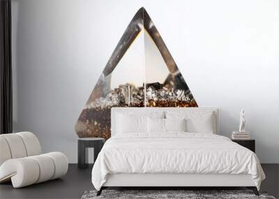 a smooth orgonite cone with a clear resin finish and embedded metal particles, isolated on white background Wall mural