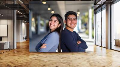 portrait of a couple of happy smiling hispanic latinos college students posing back to back Wall mural