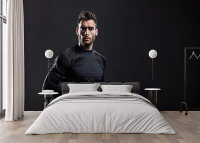 Studio portrait of a soccer goalkeeper on black background Wall mural