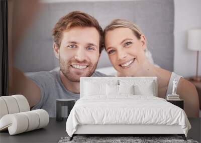 A selfie in bedroom of man and woman as couple. Portrait of young, happy and smiling people taking a picture together in the morning and wearing pajamas. Taking a photo with smile, bonding and love Wall mural