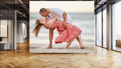 Love, dance and couple dancing at the beach in summer celebrate their marriage, happiness and honeymoon vacation. Smile, sunset and happy woman celebrating a healthy relationship with partner at sea Wall mural