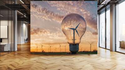 Glowing light bulb on nature landscape and wind turbines. Alternative energy concept. Wall mural