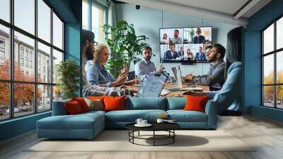 Diverse company employees having online business conference video call on tv screen monitor in board meeting room. Videoconference presentation, global virtual group corporate training, Generative AI Wall mural