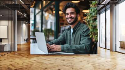 Smiling young Latin business man using laptop sitting outdoor. Happy guy student or professional looking away in city cafe elearning, hybrid working, searching job online thinking, Generative AI Wall mural