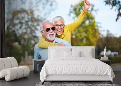 senior couple love together happy hug home family elderly man woman retirement smiling piggyback Wall mural