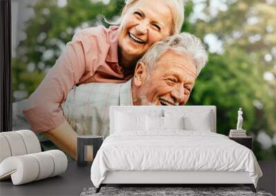 woman man outdoor senior couple happy lifestyle retirement together smiling love fun elderly active vitality nature mature portrait piggyback game Wall mural