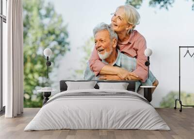 woman man outdoor senior couple happy lifestyle retirement together smiling love fun elderly active vitality nature mature portrait piggyback game Wall mural