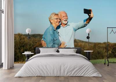 woman man outdoor senior couple happy lifestyle retirement together smiling love selfie camera mature Wall mural