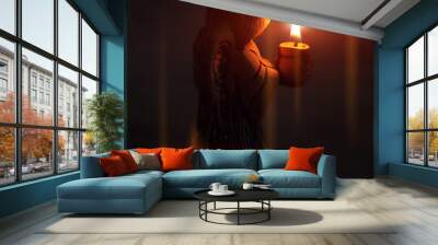 angel holds a burning candle at sunset. background religion, prayer. Wall mural