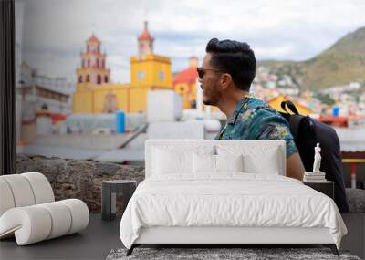 Mexican man traveling in Guanajuato. Student exploring a colorful city.  Wall mural