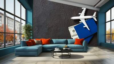 Airplane model, two passports and money on a dark background. Travel concept with copy space. Wall mural