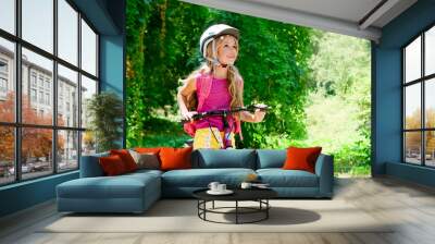 Children girl riding bicycle outdoor in forest smiling Wall mural