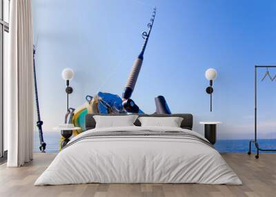 fishing boat trolling in ocean with golden reel Wall mural