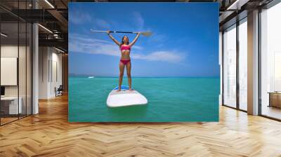 Girl standing on paddle surf board SUP Wall mural