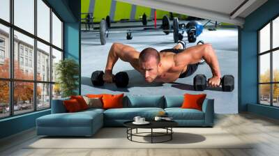 Gym man push-up strength pushup exercise with dumbbell Wall mural