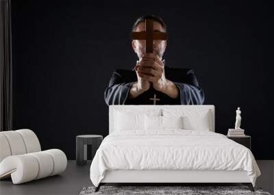 Priest holding cross of wood praying Wall mural