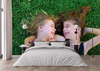 sisters kid girls smiling lying on garden grass Wall mural