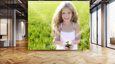 sprout plant growing from little girl hands outdoo Wall mural