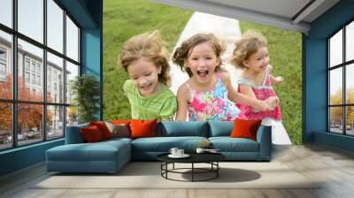 Three sister girls playing running on the park Wall mural