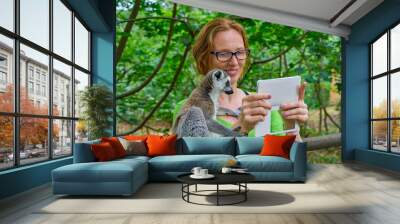 woman taking photo selfie with ring tailed lemur Wall mural