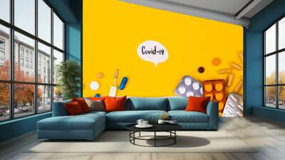 Protective medical mask on yellow background surrounded with colorful pills. Creative concept of healthcare, hygiene, virus protection and medical treatment on coronavirus quarantine Wall mural