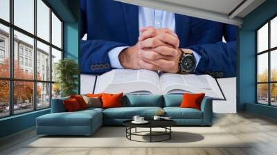 Closeup, hands and man with bible, praying and guidance with higher power, hope and spiritual. Zoom, male and Christian with holy book, scripture and religious with faith, Catholic text and belief Wall mural